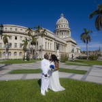 newly married couple standing in front of a beautiful building in Havana